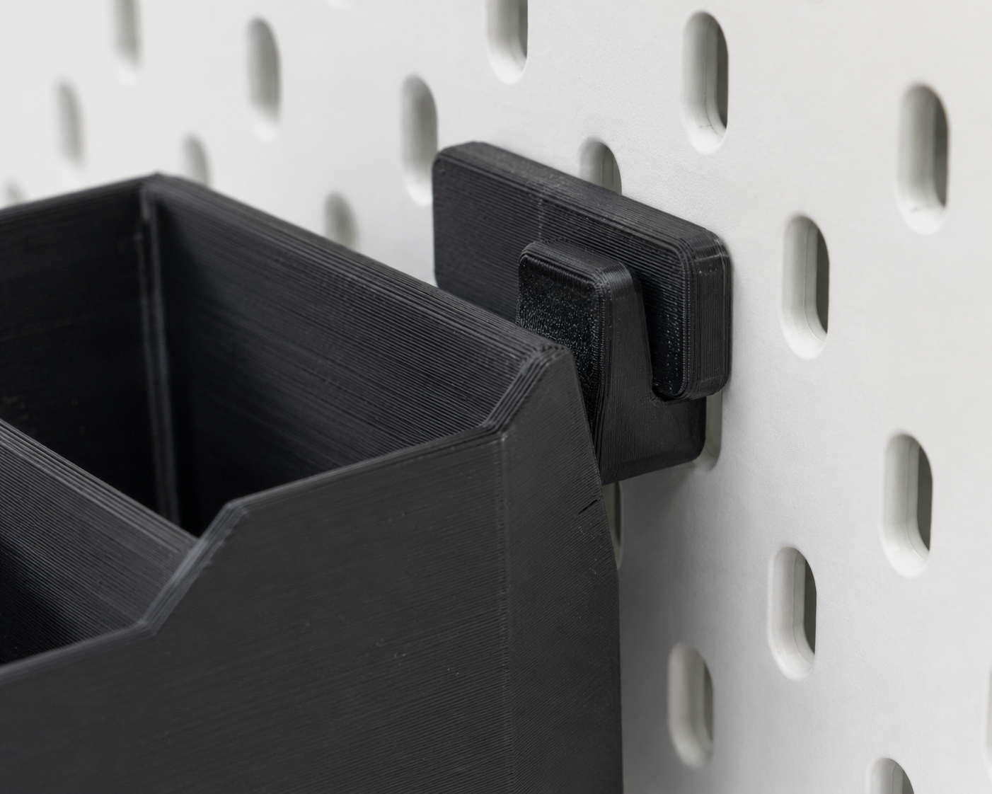 Nahaufnahme 3D-gedruckter Clip-Mechanismus am modularen Wandregal GRID — werkzeuglose Befestigung an Lochplatte